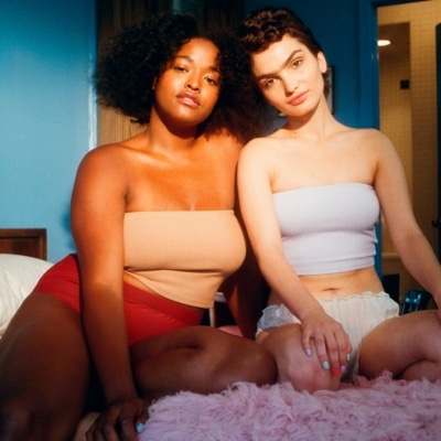 Deux femmes en sous-vêtements assise sur un lit