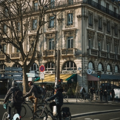 Deux personnes sur des vélos dans la rue en bas d'un grand bâtiment