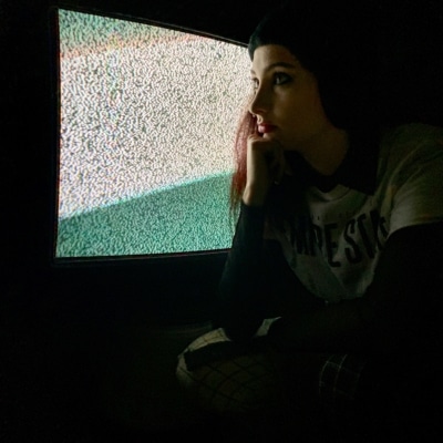 Jeune femme regardant une télé avec l'image saturée