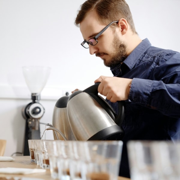 Serveur homme ou Barista servant du café et des boissons chaudes dans des tasses et verres