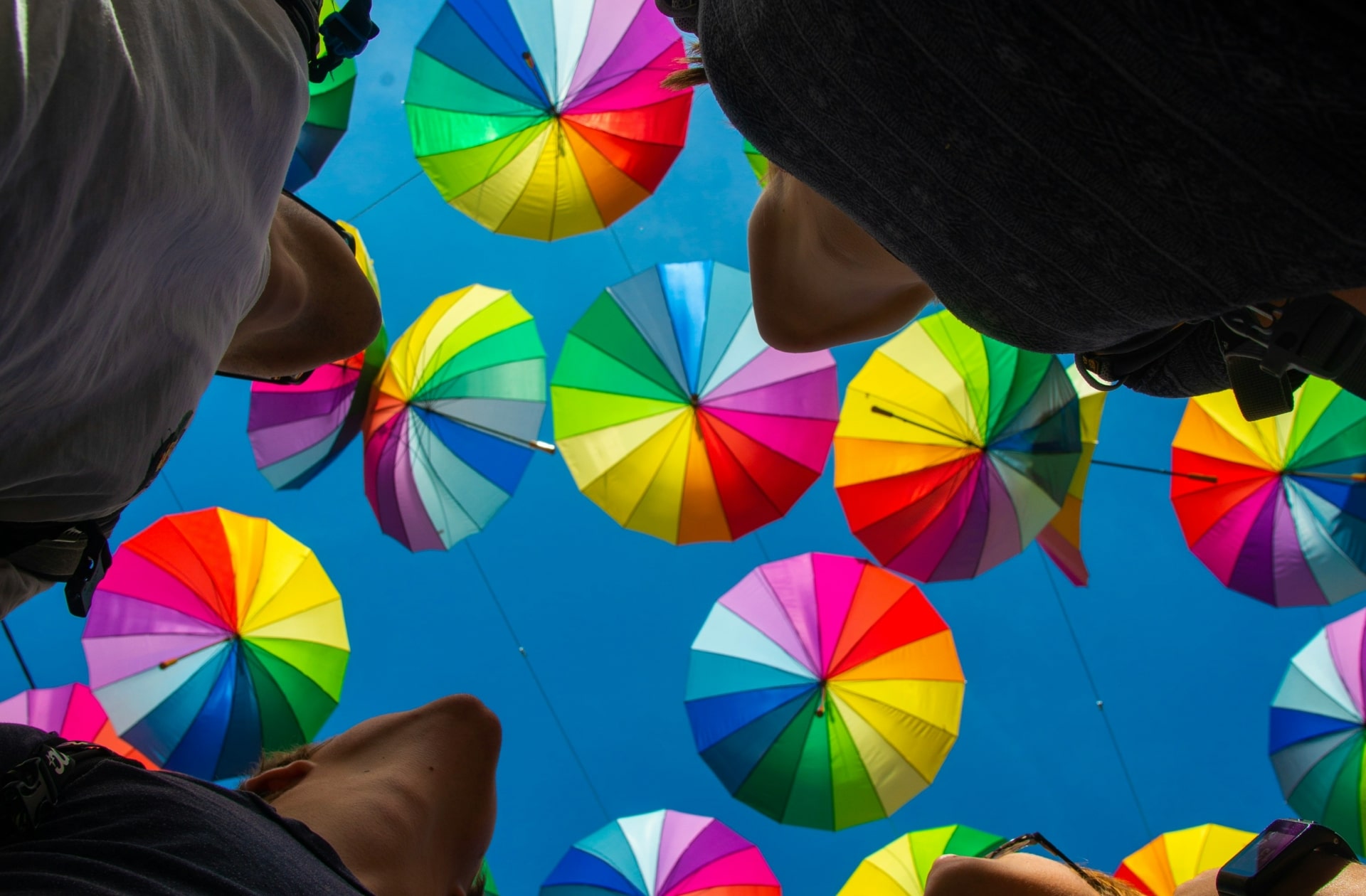 Groupes de personnes regardant le ciel rempli de parapluie multicolore