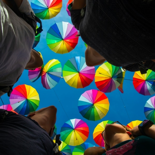 Groupes de personnes regardant le ciel rempli de parapluie multicolore