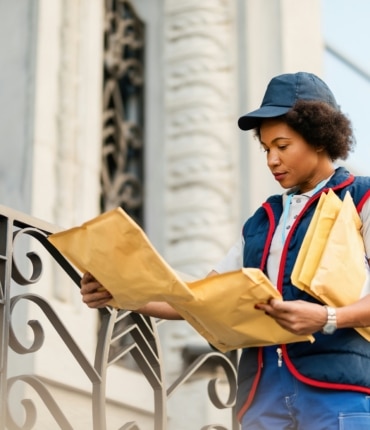 une femme tenant des courriers dans les mains dans une rue